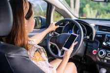 young-female-driver-holding-a-smart-phone-with-co-2021-10-06-09-53-10-utc.webp
