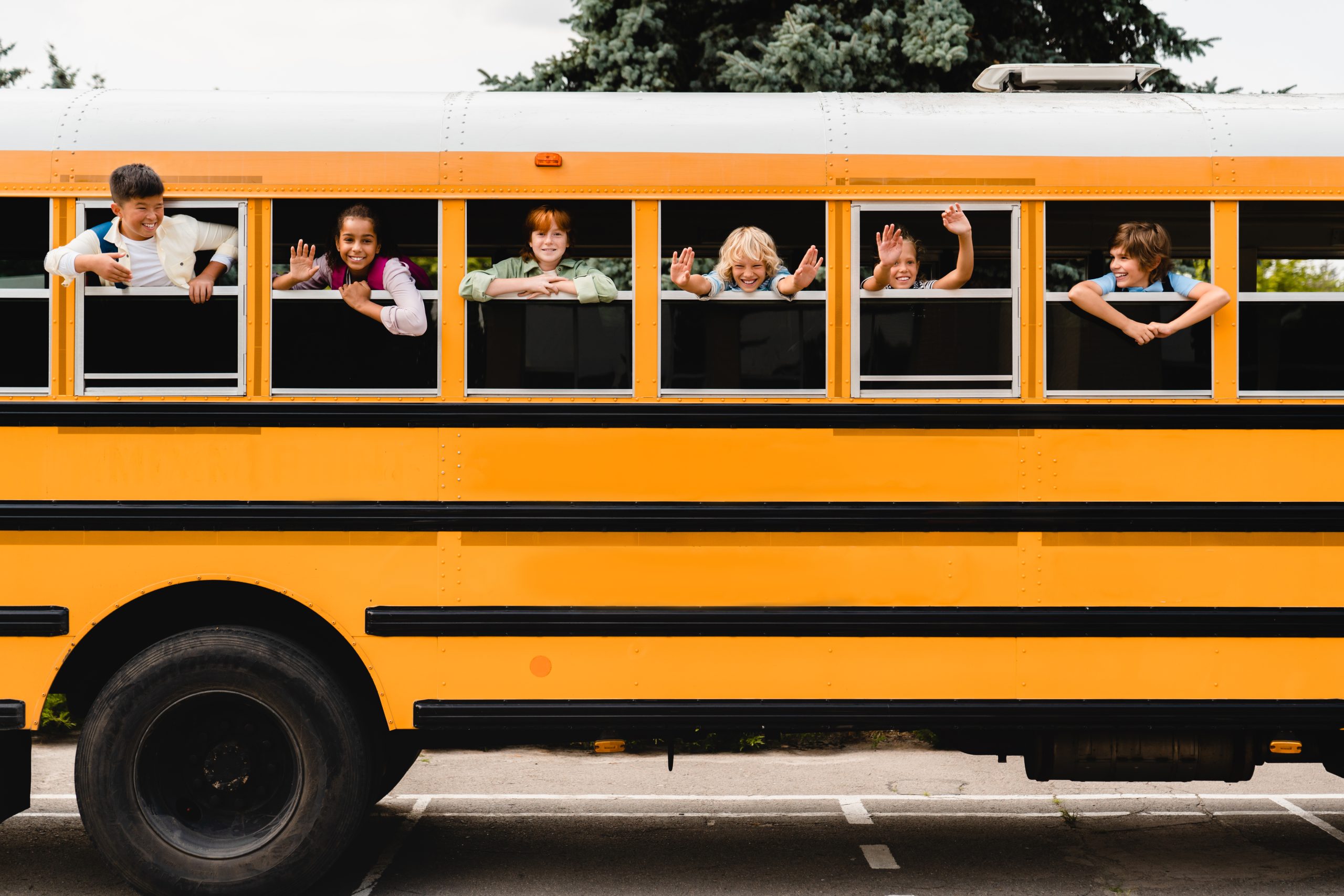 Front view of schoolchildren classmates pupils looking out of the school bus waiting for new educational year semester, coming back to school lessons and homework.