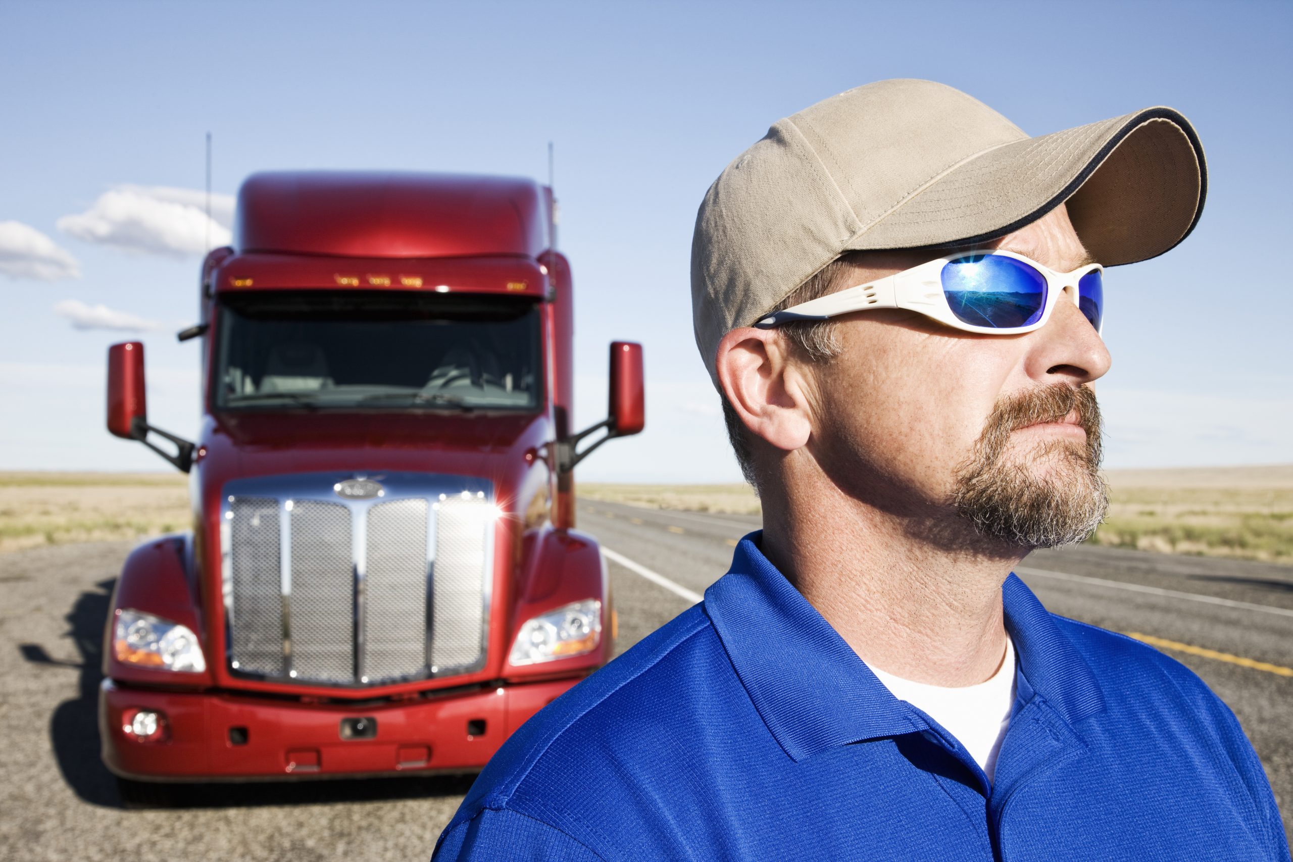 Portrait of a Caucasian man driver and his commercial truck.