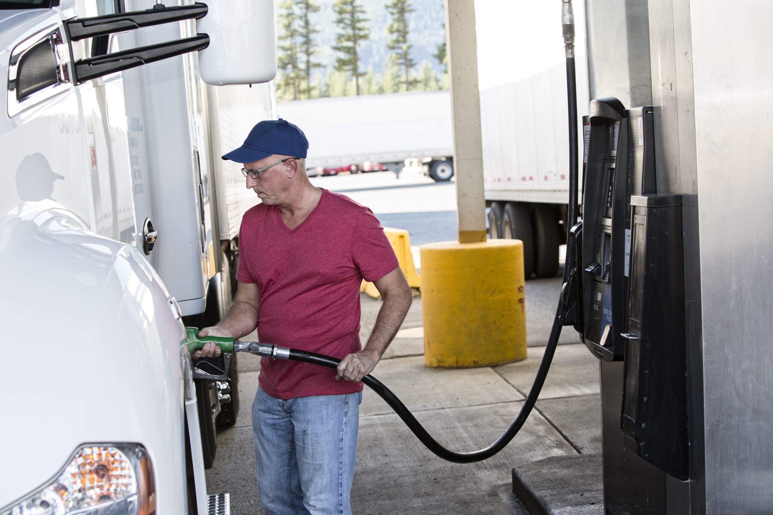 truck driver putting fuel in a semi truck